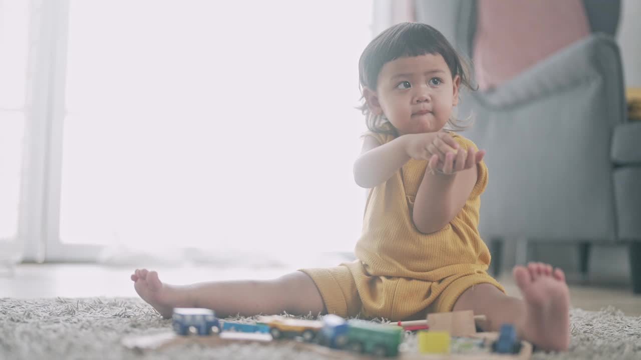 亚洲妈妈和小女孩在客厅里学习玩五颜六色的木制玩具视频下载