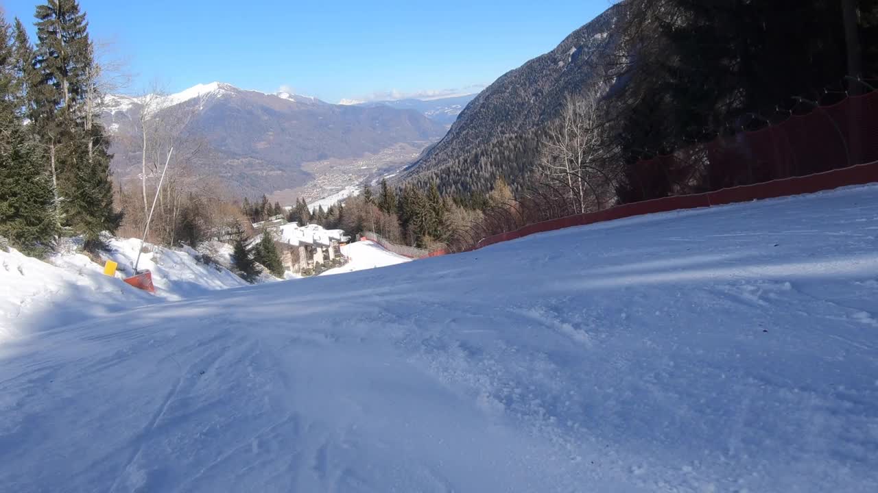 一个成年女子在斜坡上滑雪的跟踪镜头视频素材