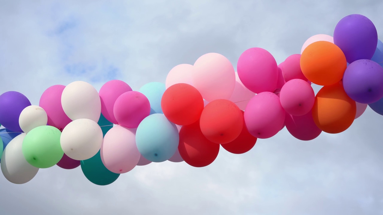 一束长长的彩色气球悬挂在空中视频下载