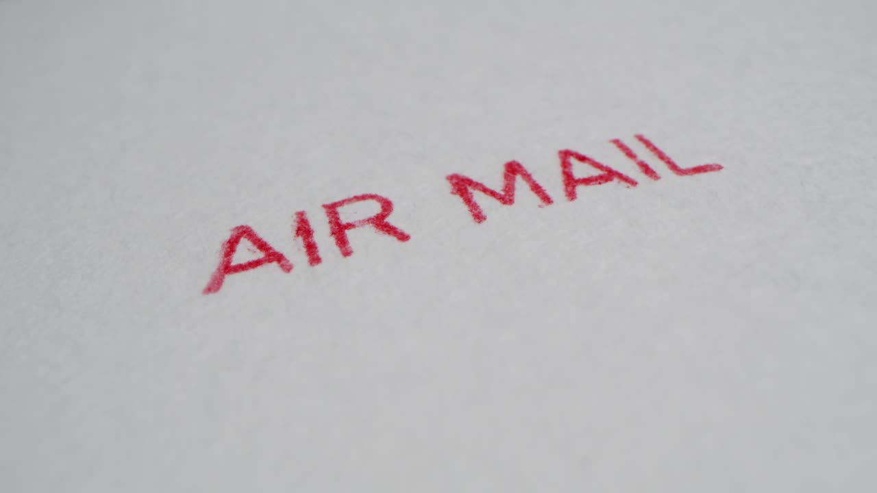 一张航空邮件邮票被放在一张白纸上(特写)视频下载