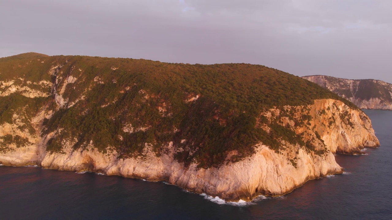 鸟瞰图:美丽的海滩和水湾在希腊壮观的海岸线。日落华丽的天空在蓝色的水独特的岩石悬崖。希腊夏季首选旅游目的地莱夫卡达岛视频下载