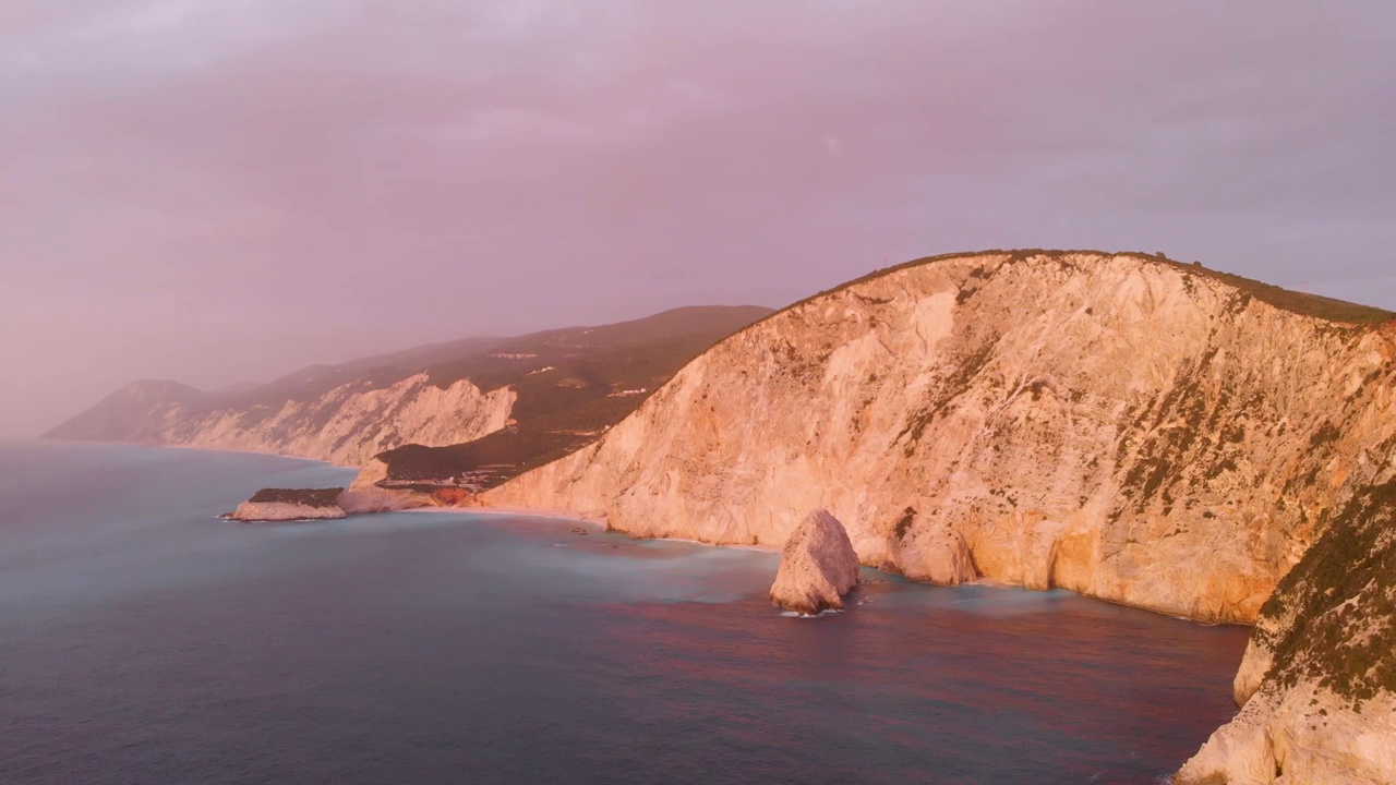 鸟瞰图:美丽的海滩和水湾在希腊壮观的海岸线。日落华丽的天空在蓝色的水独特的岩石悬崖。希腊夏季首选旅游目的地莱夫卡达岛视频下载