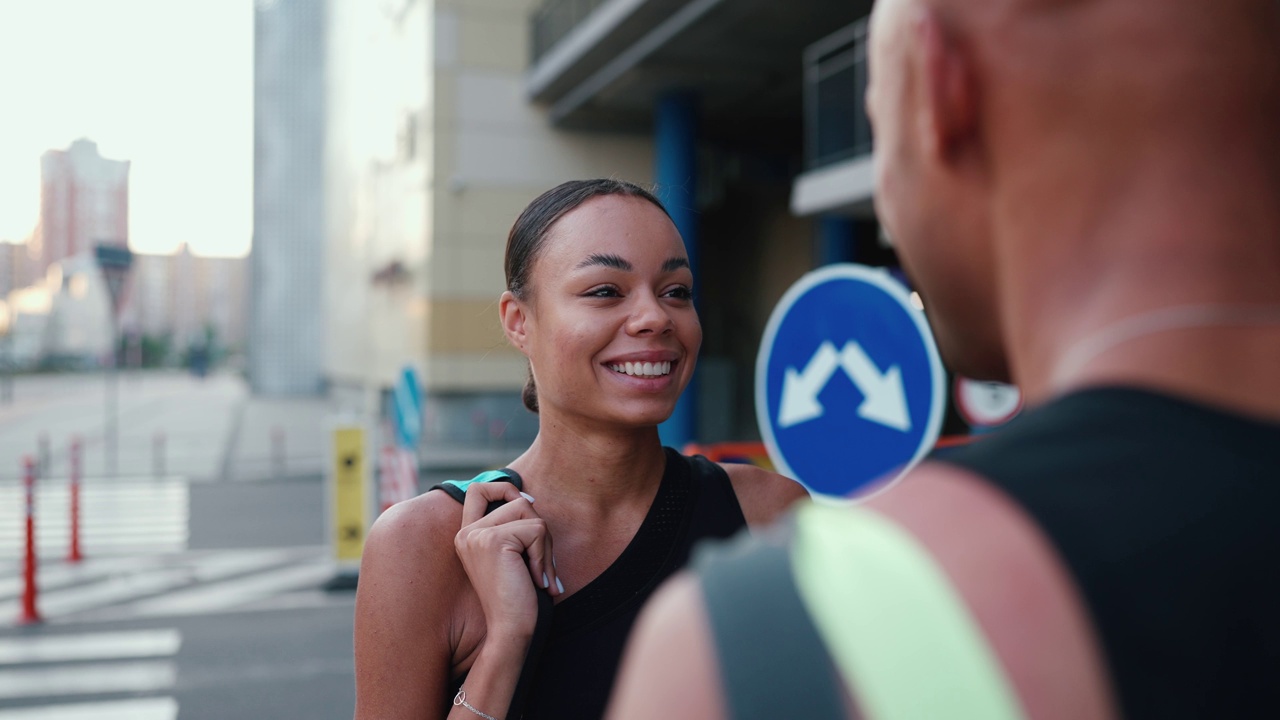 快乐的非洲运动男人和女人在停车场附近聊天视频下载