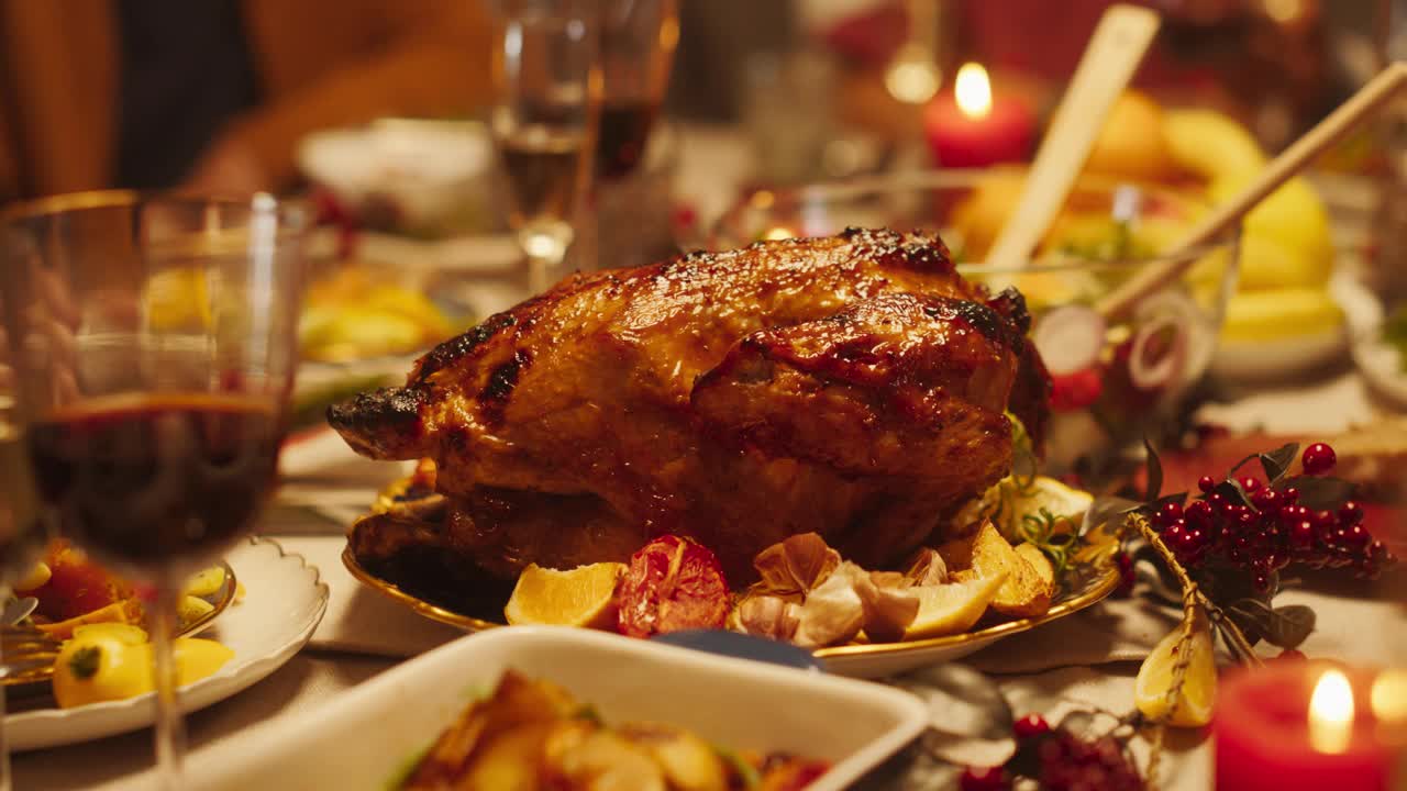 美味的饭菜和节日装饰准备家庭晚餐在家里庆祝感恩节或圣诞节。美味的特写火鸡与烤土豆在节日餐桌上视频下载