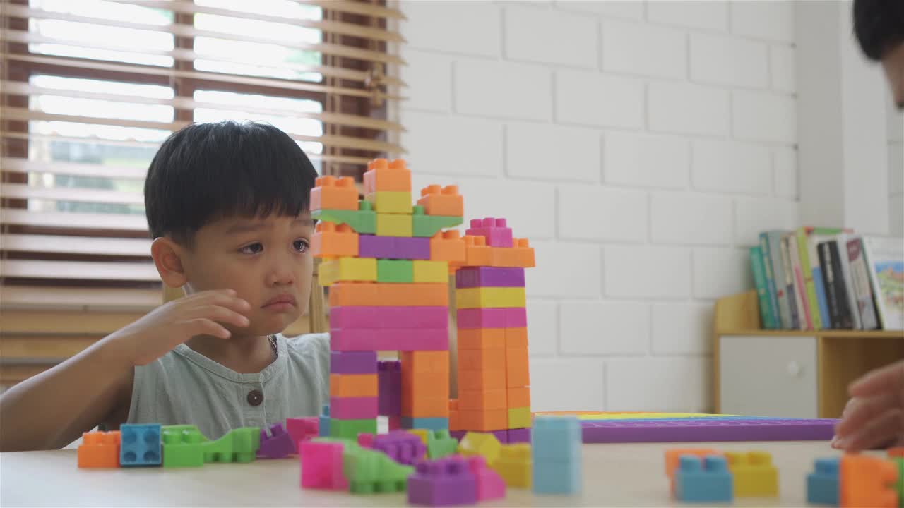 亚洲小男孩在家里的房间里玩塑料积木视频下载