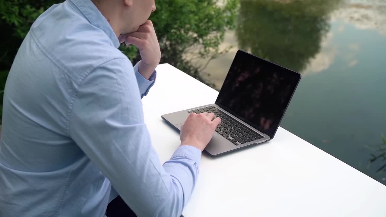 一名男子在户外用笔记本电脑工作视频下载