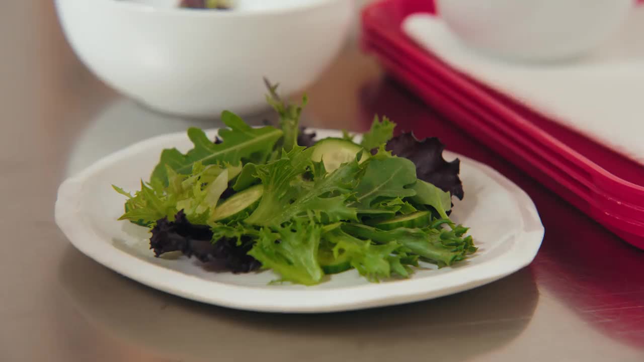 一位专业厨师美食摄影师烹饪艺术家在绿叶沙拉碗上镀上薄薄的葱片，在厨房工作空间用一套精致的镊子拍摄食物照片视频下载
