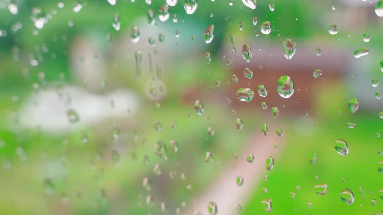 在一个秋雨的日子里，模糊的窗户背景。水珠落在玻璃上视频素材