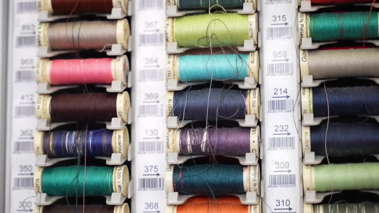 在专业的裁缝工作室，多色棉线在垂直板上旋转，在裁缝车间收集高品质的面料线，用于刺绣或衣服修补。针线活和制造理念视频素材