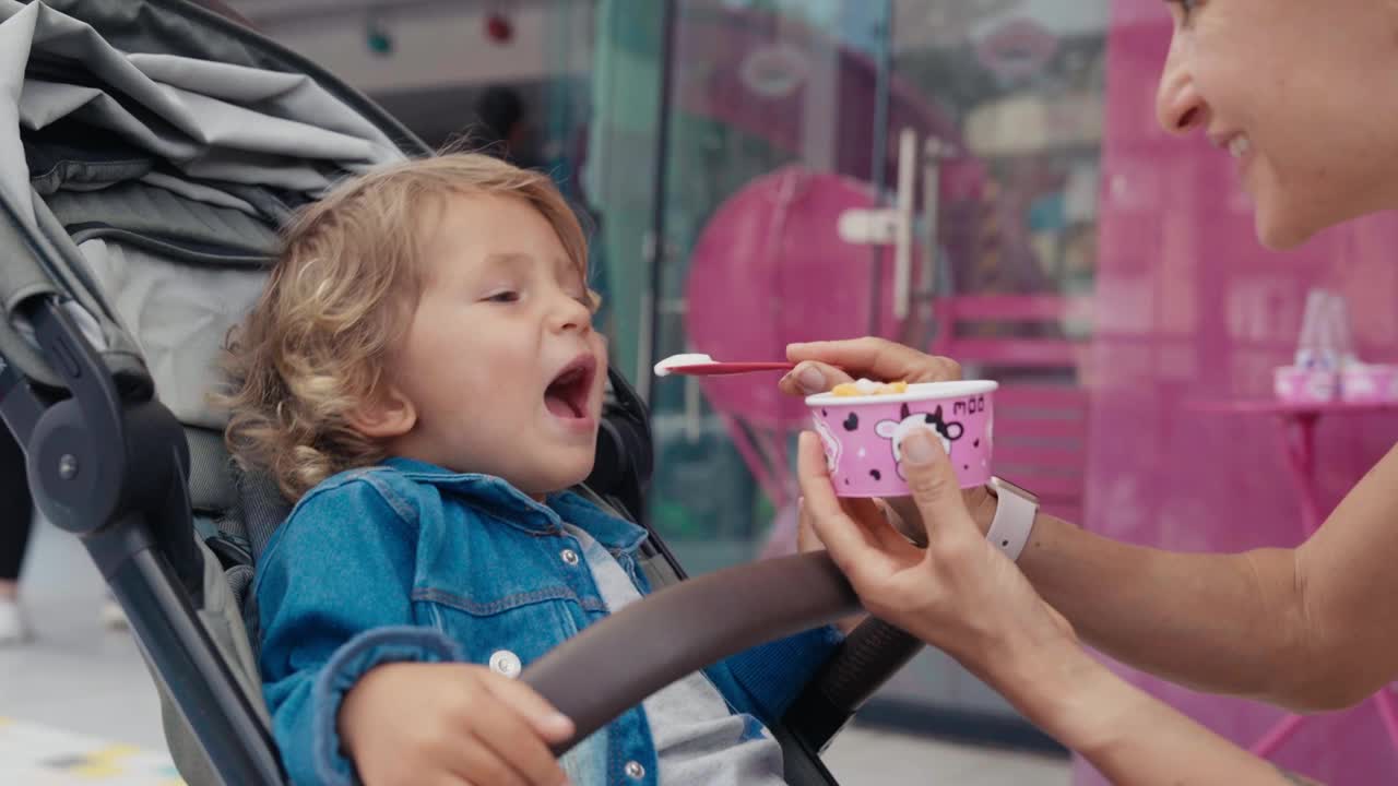 一个小男孩和一个年轻女人一起吃冰淇淋的特写。高品质4k画面视频下载