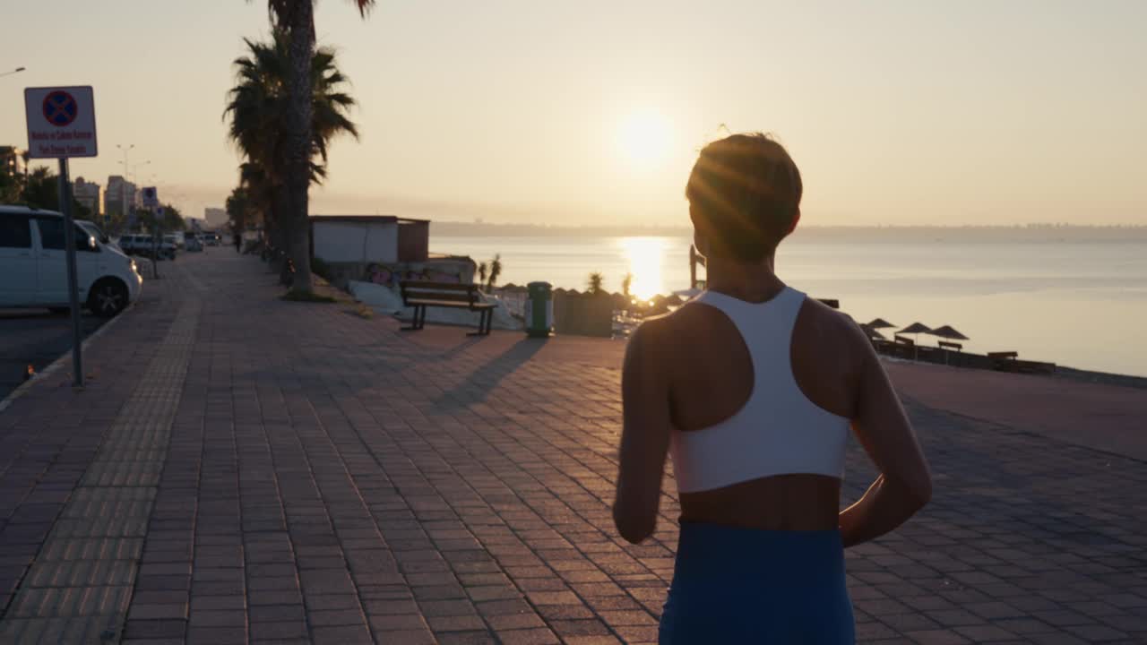 年轻的健身运动女子在日落时分在路上跑步。运动员跑步者的脚在路上跑，慢动作。高品质4k画面视频下载