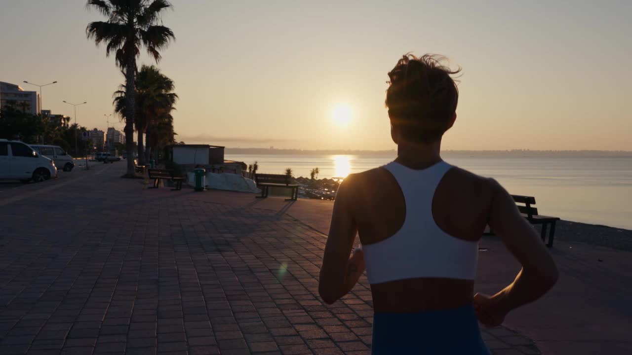 年轻的健身运动女子在日落时分在路上跑步。运动员跑步者的脚在路上跑，慢动作。高品质4k画面视频下载