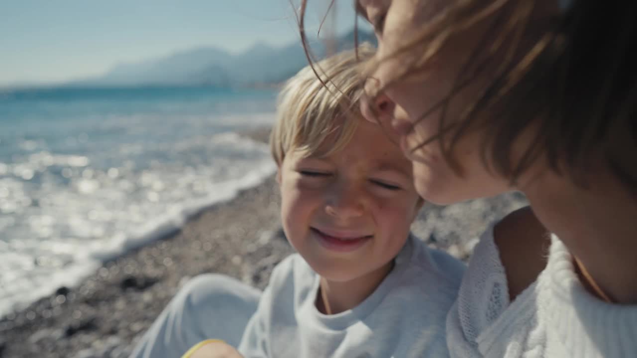 海滩上幸福的一家人。母亲节快乐，兴奋的男孩儿女和阳光海。视频下载