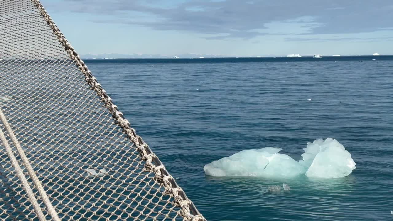 一块冰平静地漂浮在帆船旁边。Scoresbysund,格陵兰岛。视频素材