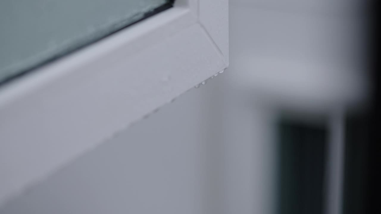 雨天，雨滴在房子的现代白色窗户角落的慢动作视频下载