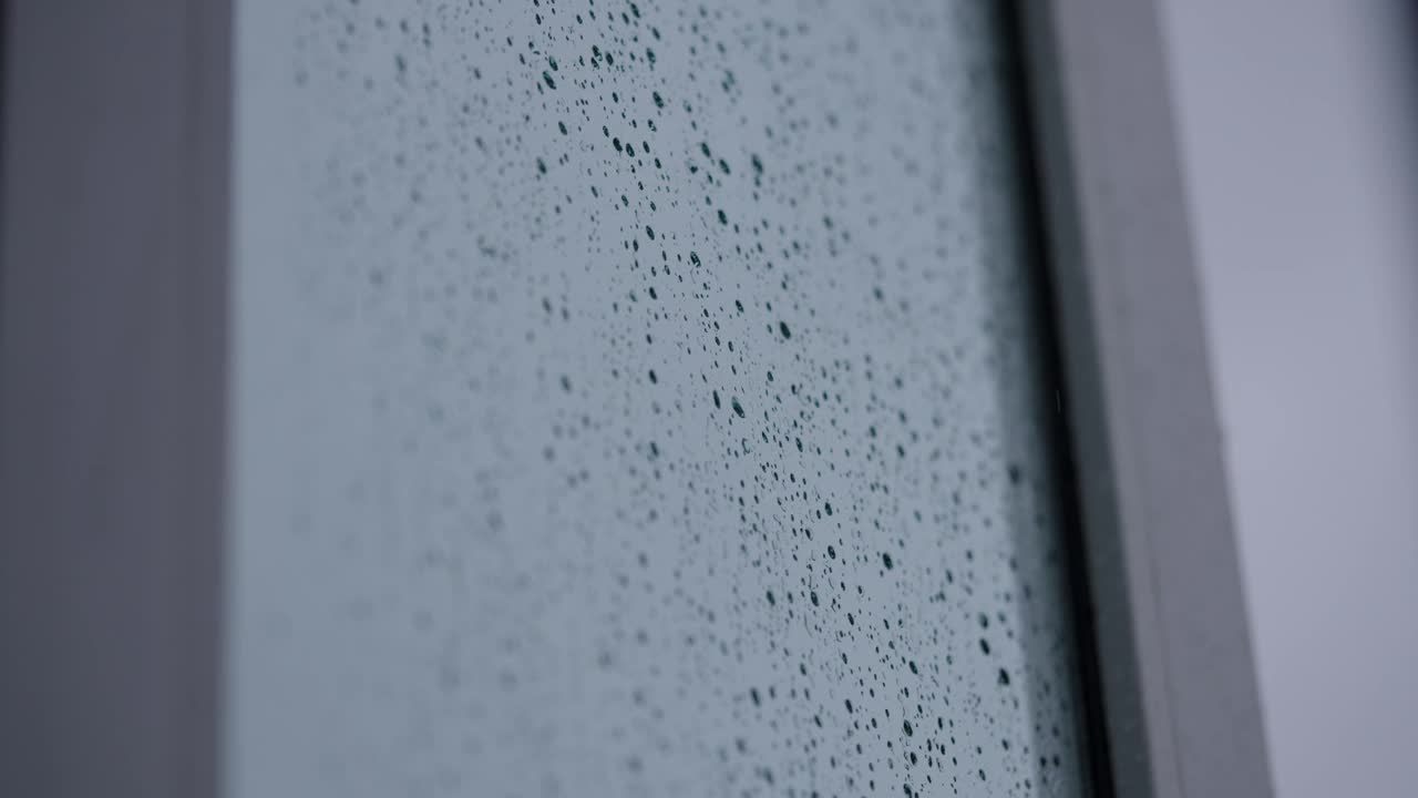 在黑暗的日子里，房子窗户上的4K雨线慢动作，文字的复制空间视频下载