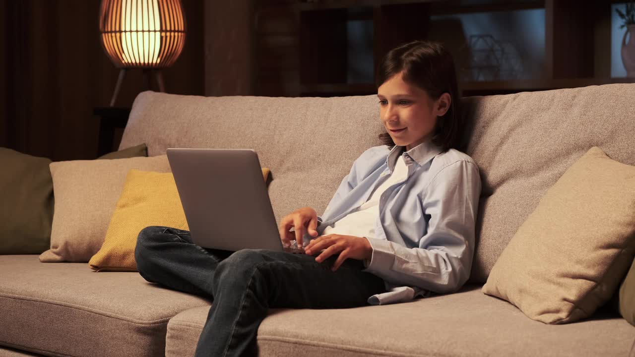 晚上在客厅用笔记本电脑看新闻的男孩视频下载