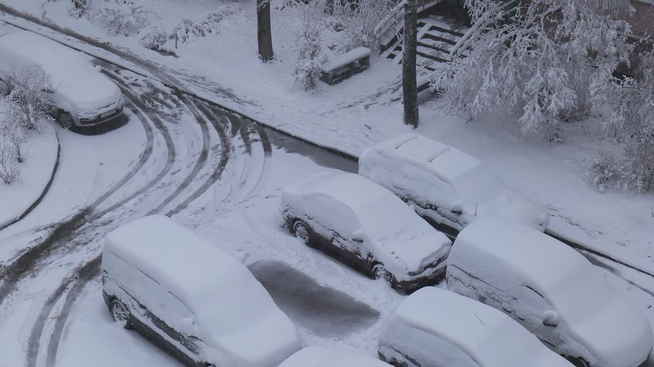 积雪覆盖的汽车停在下雪的停车场里视频下载