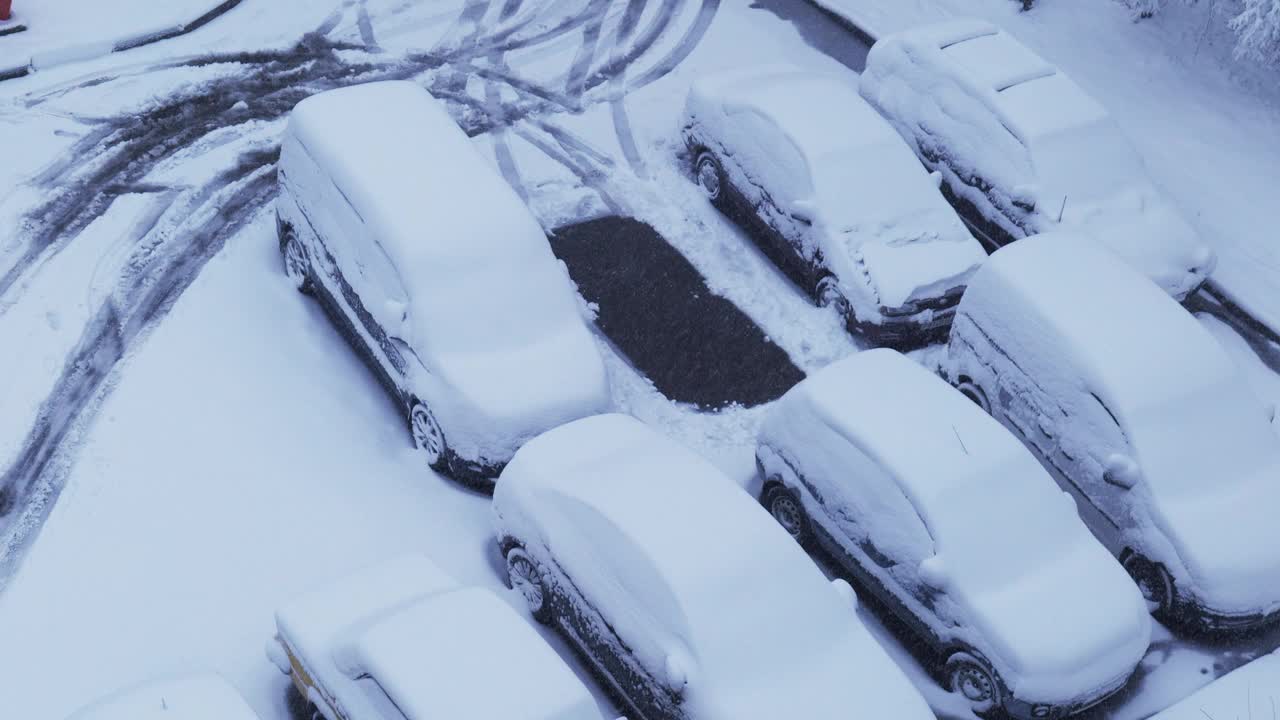 积雪覆盖的汽车停在下雪的停车场里视频下载