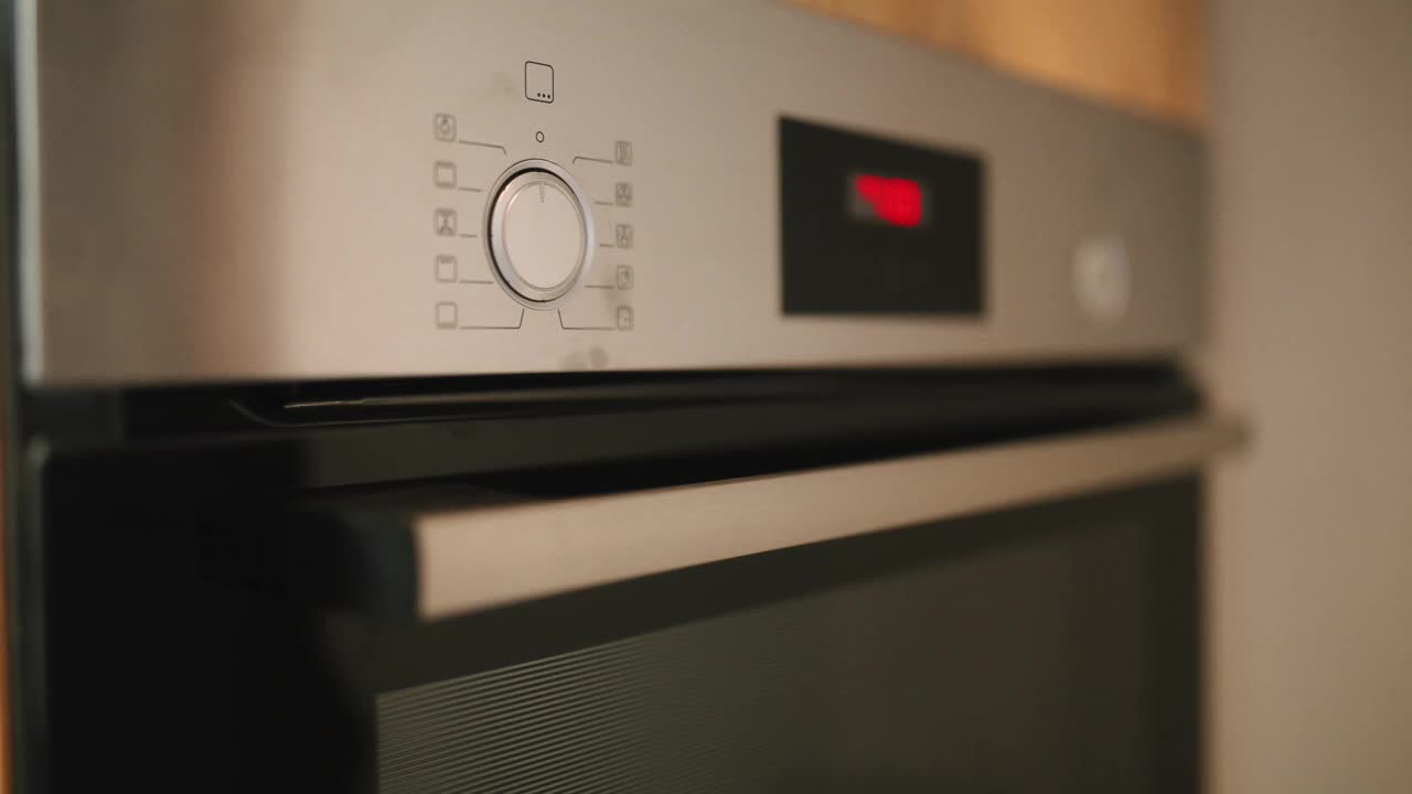 一个女人正在给家里的烤箱设定温度视频下载