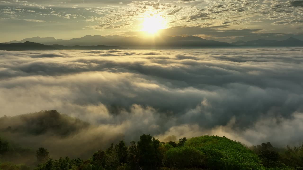 空中无人驾驶飞机向前飞行，穿过山脉，在雾海上展示美丽的日出视频下载
