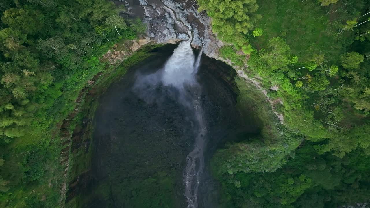 自顶向下鸟瞰图无人机下降和倾斜显示Coban Sriti瀑布，爪哇，印度尼西亚视频下载