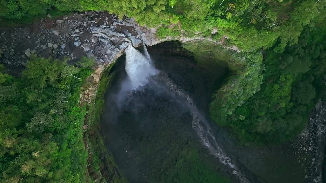 自顶向下鸟瞰图无人机下降和旋转显示Coban Sriti瀑布，爪哇，印度尼西亚视频下载