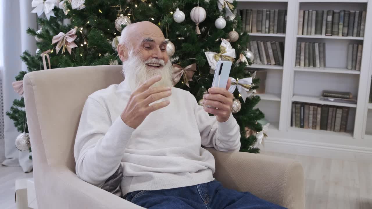 快乐的退休老人通过智能手机微笑着与朋友进行视频通话视频下载