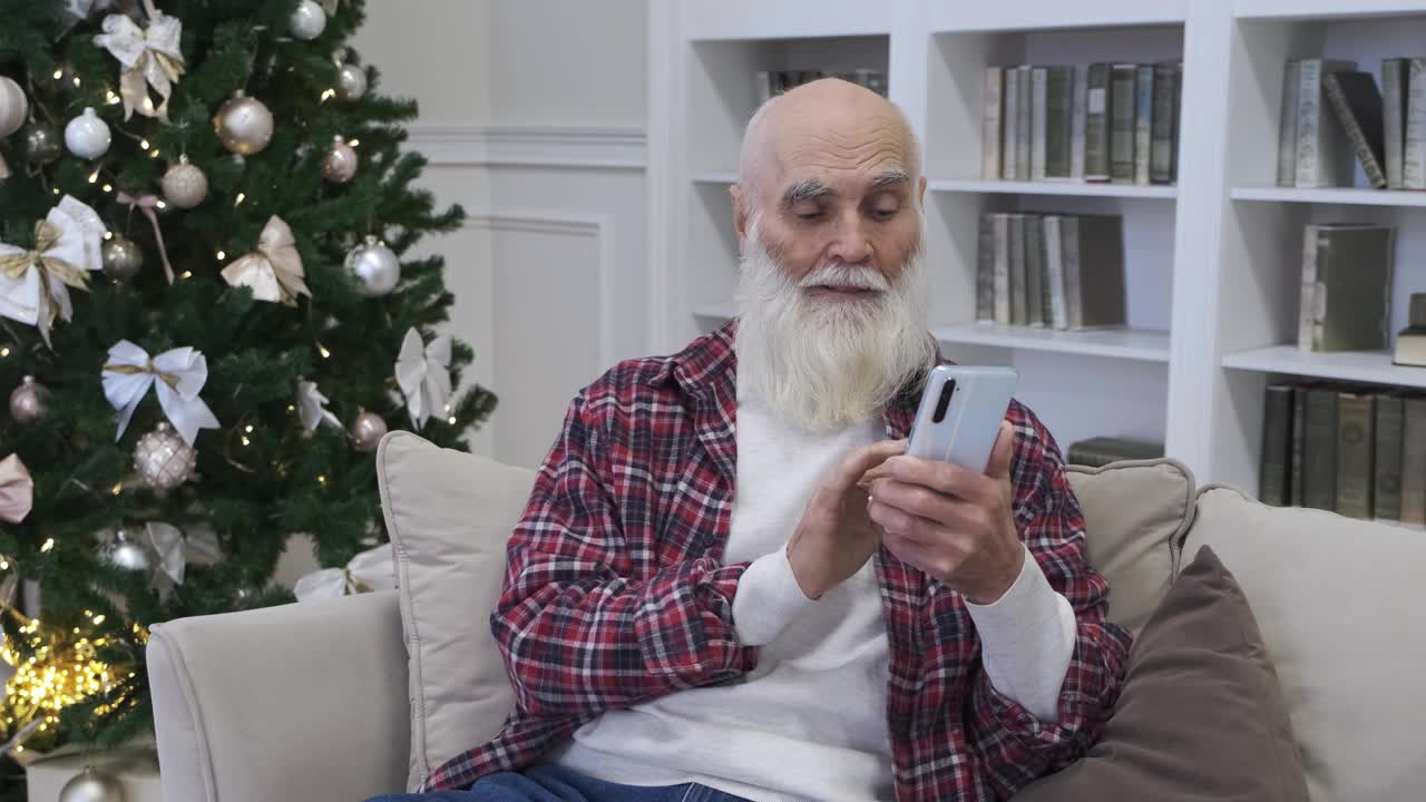 开朗的80多岁老人喜欢在家用智能手机看搞笑视频视频下载