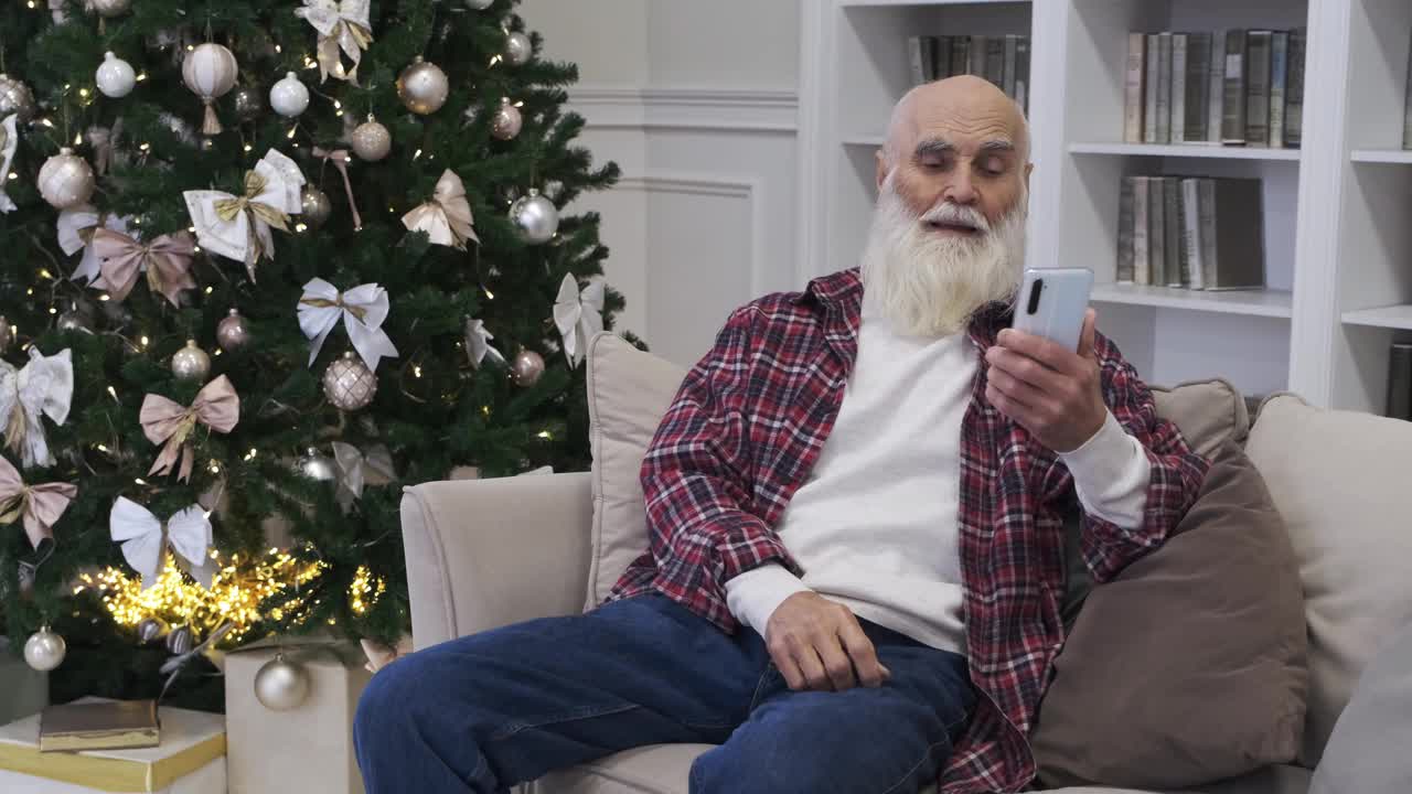 一位老人在现代智能手机上看孙子孙女的照片视频下载