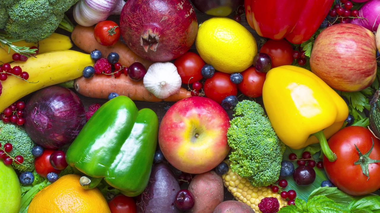 餐桌上有各种新鲜收获的水果、蔬菜和浆果。健康饮食纯素和素食。俯视图视频下载