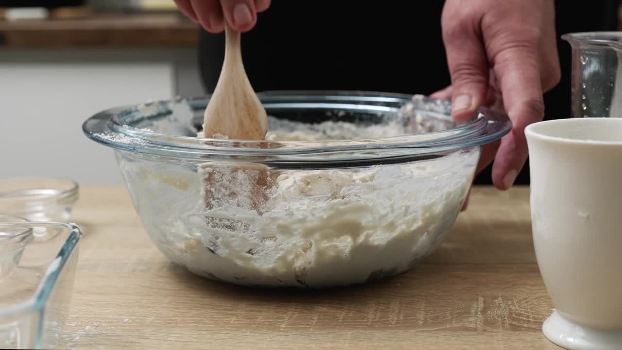 家庭厨师用手把食材混合在一起，为美味的自制面包准备面团。视频素材