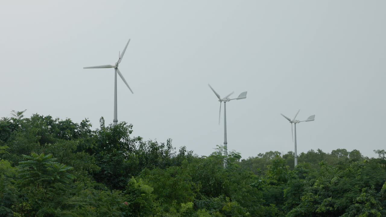 在雨季，风力涡轮机在灰色的天空中快速旋转。视频下载