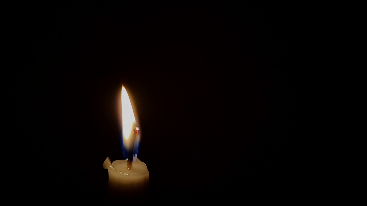蜡烛火焰在黑色背景上孤立燃烧视频下载