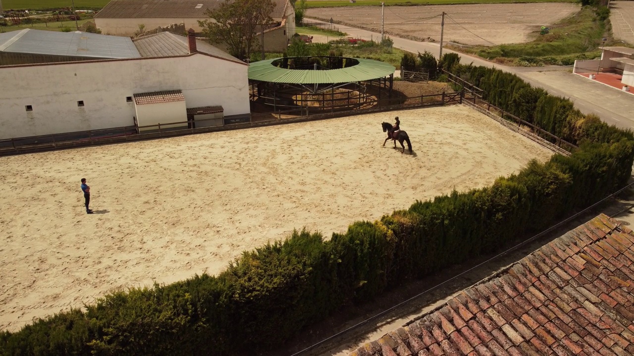 在一个骑马中心，一个年轻的骑师在接受骑马课程。视频下载