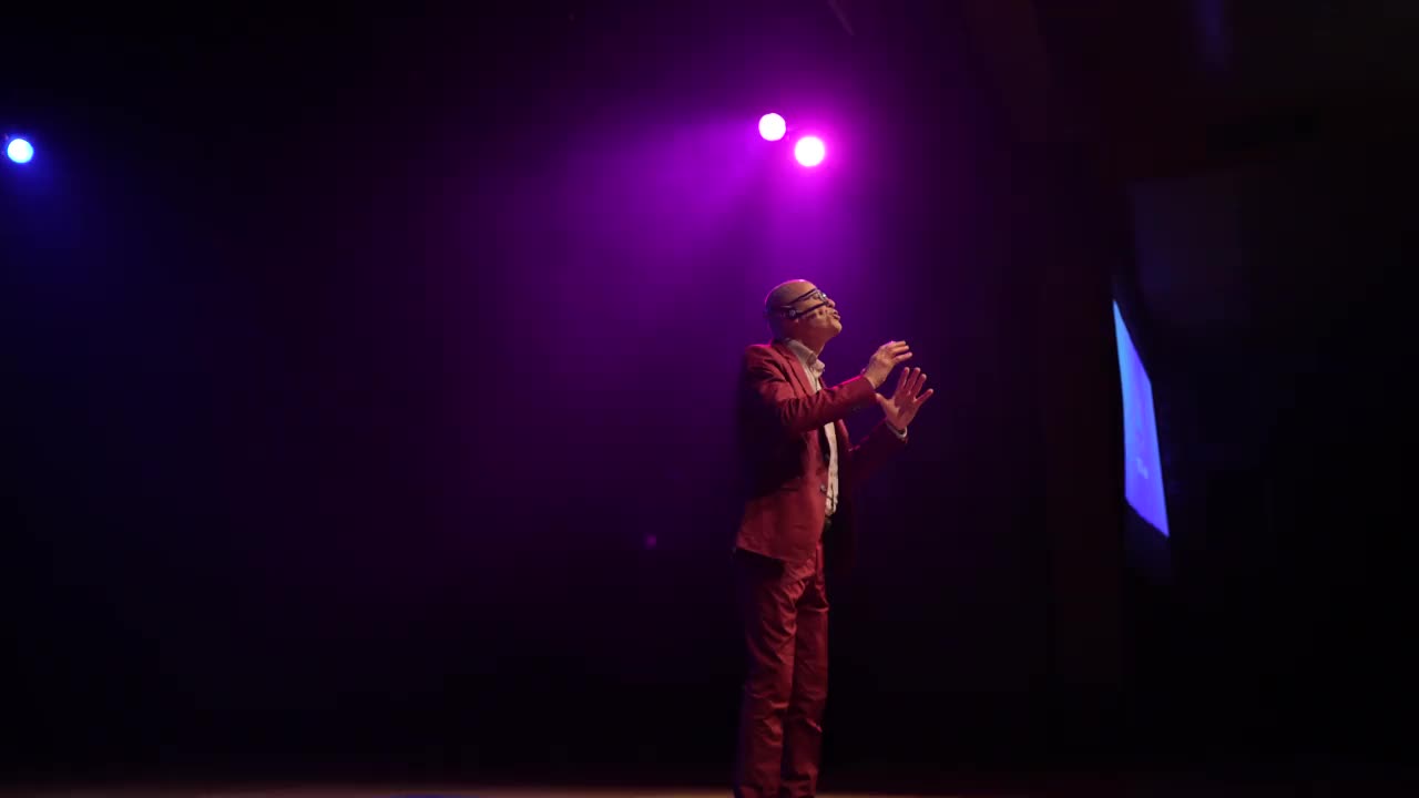 一名西装革履的男子在舞台上用头戴式麦克风讲话视频下载