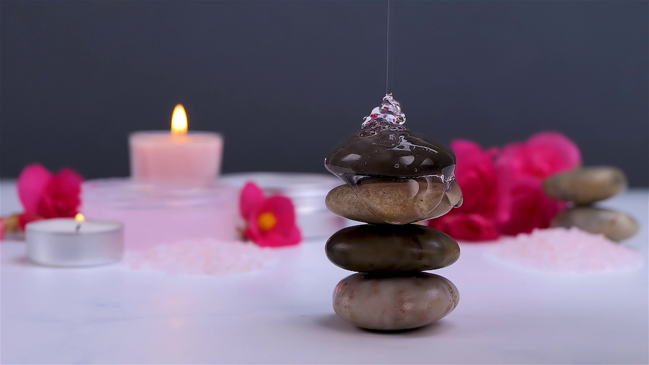 沐浴露流在温泉石与身体护理产品和蜡烛视频下载