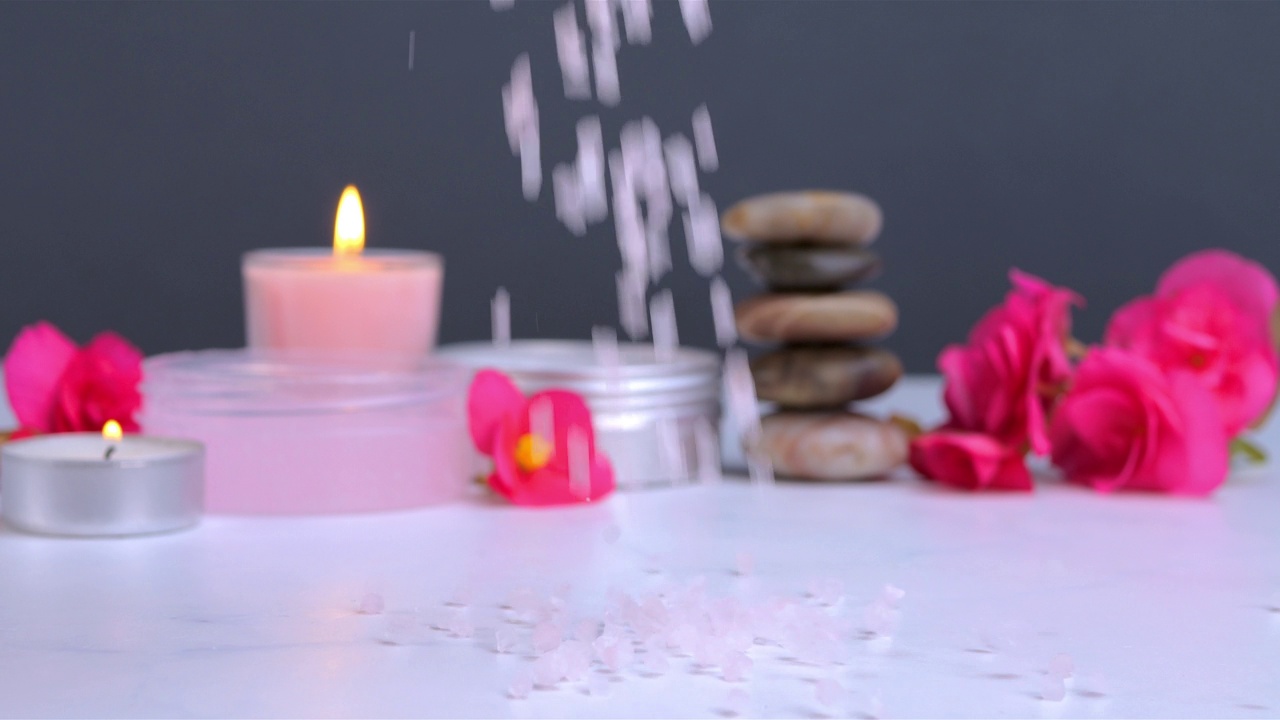 白色的桌子上，洒着蜡烛的浴盐和水疗用的沐浴露视频下载