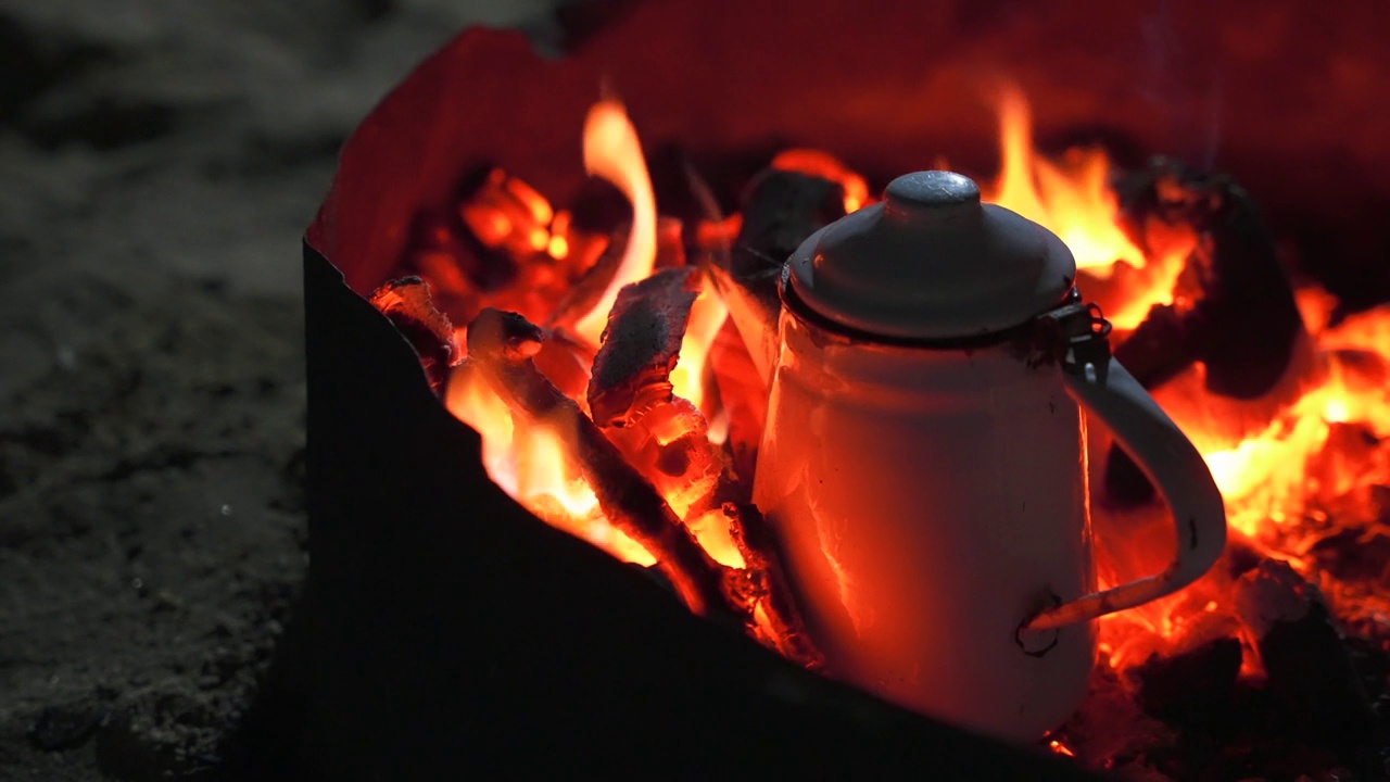 篝火中烧煤的金属水壶近照。晚上在沙漠里泡贝都因茶视频素材