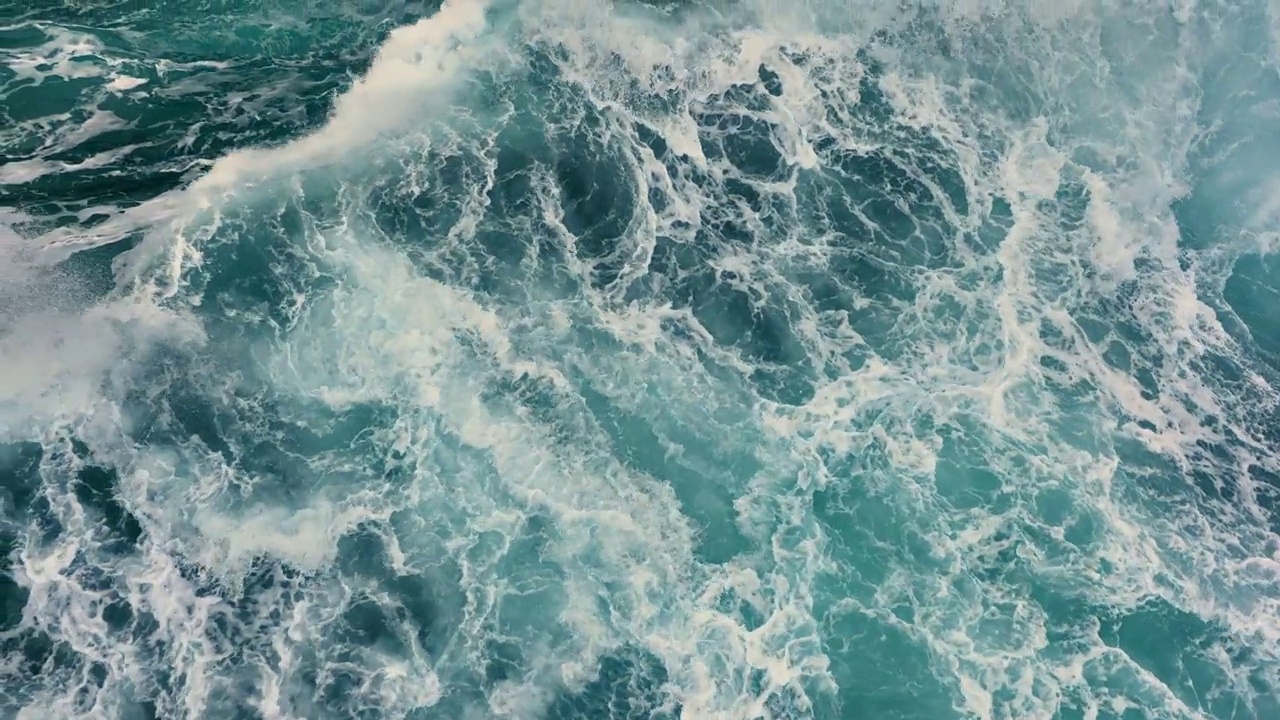 空中俯瞰的海洋风暴海浪。大海的海浪与白色的泡沫和蓝色的水。慢镜头，4K视频下载