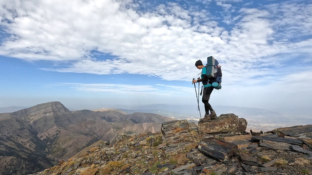 女登山者正在观赏森林和山顶的美景。视频下载