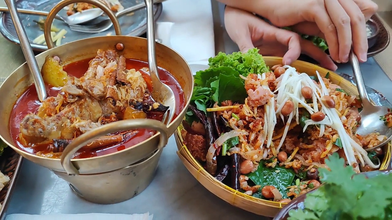 Yam Naem Khao Tod香辣猪肉沙拉香脆米饭，与蔬菜一起在回收纸盘中食用，泰国菜辛辣的开胃菜，由炒饭和辣椒酱混合腌制猪肉制成。视频下载