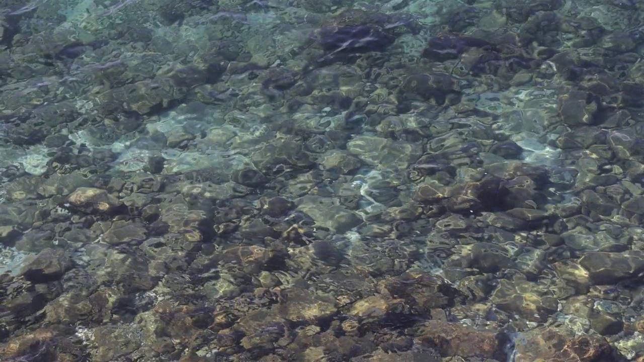鸟瞰图，蓝色的海浪在底部的石头上视频下载