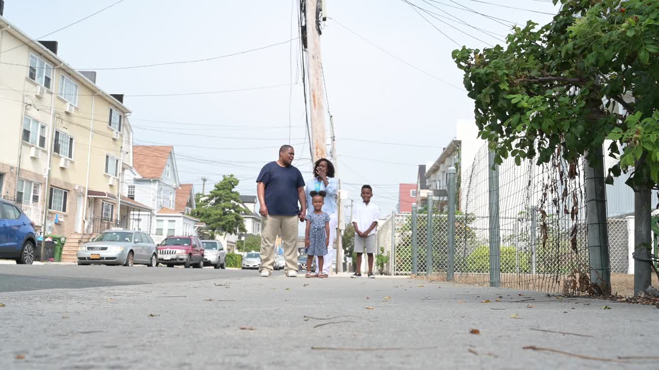 一个黑人家庭带着两个孩子在人行道上奔跑视频下载