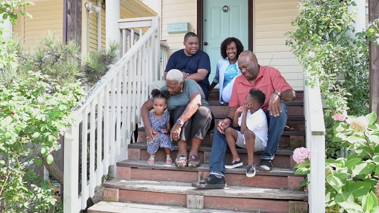 多代黑人家庭坐在阳光明媚的门前台阶上视频下载