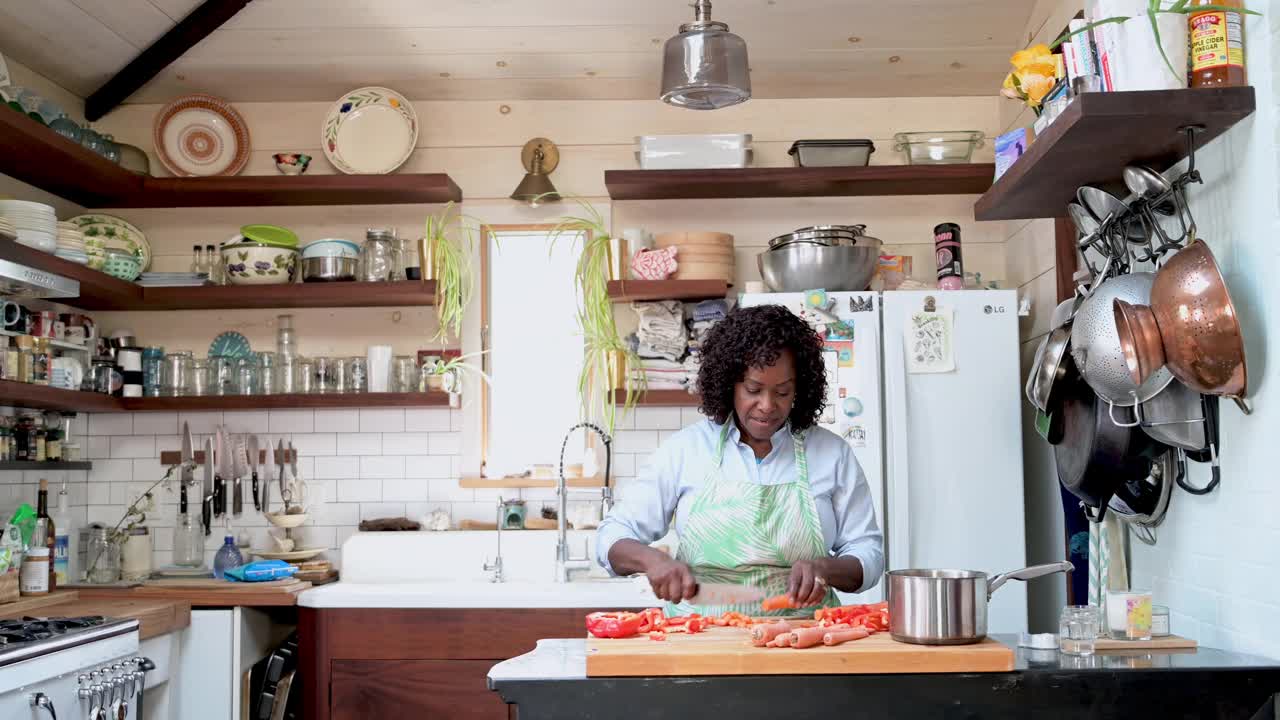 快乐的家庭厨师在舒适的厨房里切胡萝卜视频下载