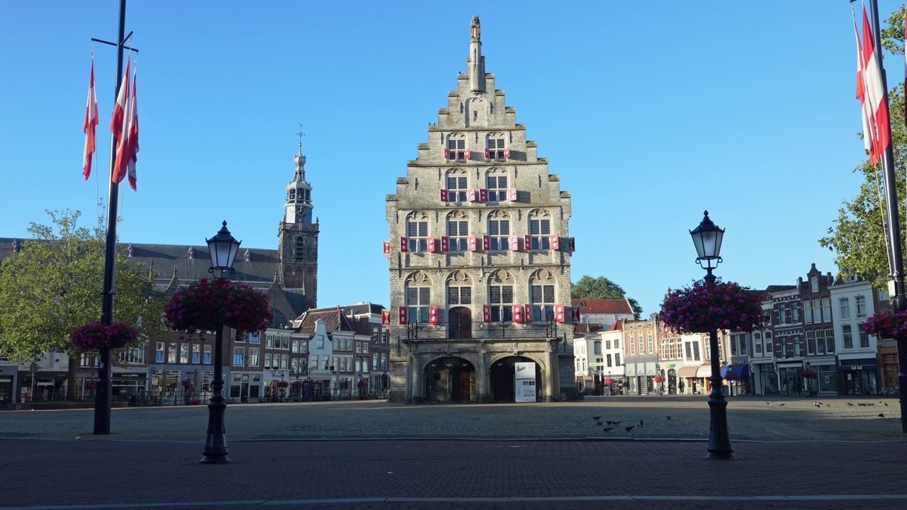 城市地标，市政厅和圣简教堂在荷兰南部的豪达老城。静态的照片视频下载