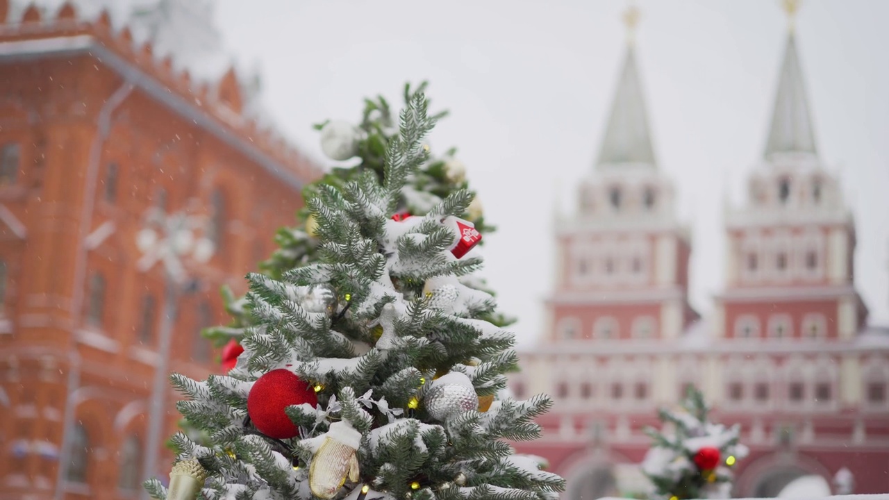 冬天的莫斯科，克里姆林宫，圣诞树上挂满了玩具和花环。在莫斯科克里姆林宫的背景下，圣诞树上飘着美丽的雪花。视频下载