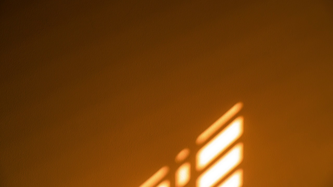 在日出时，房子墙上百叶窗的阴影会发生变化。视频素材