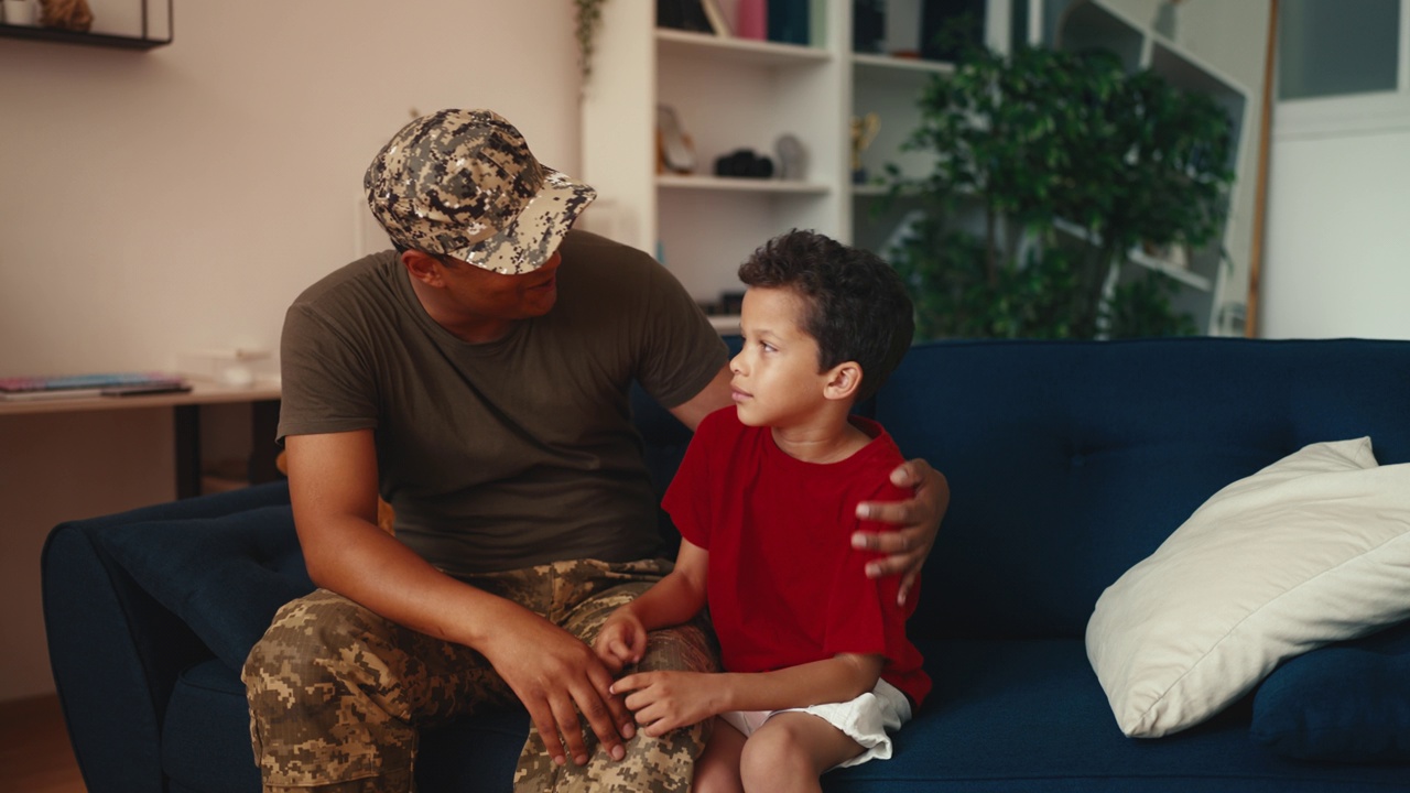 快乐的军人父亲抱着小儿子，在家里享受家庭时光视频下载